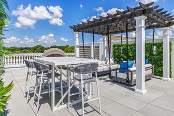A patio with a table and chairs under a pergola.